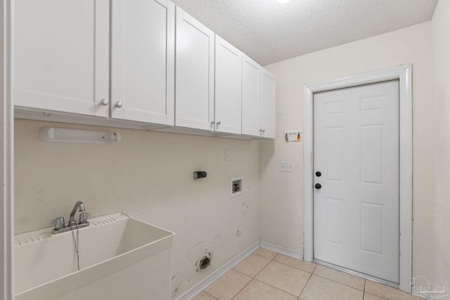 laundry area featuring light tile patterned floors, baseboards, washer hookup, cabinet space, and electric dryer hookup