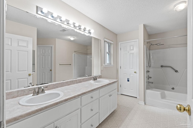 full bath with tile patterned floors, a textured ceiling, shower / bathing tub combination, and a sink