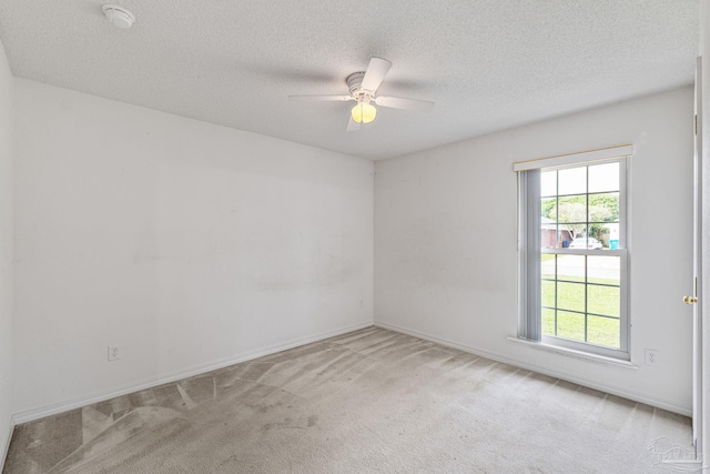 empty room with a textured ceiling, baseboards, a ceiling fan, and carpet floors