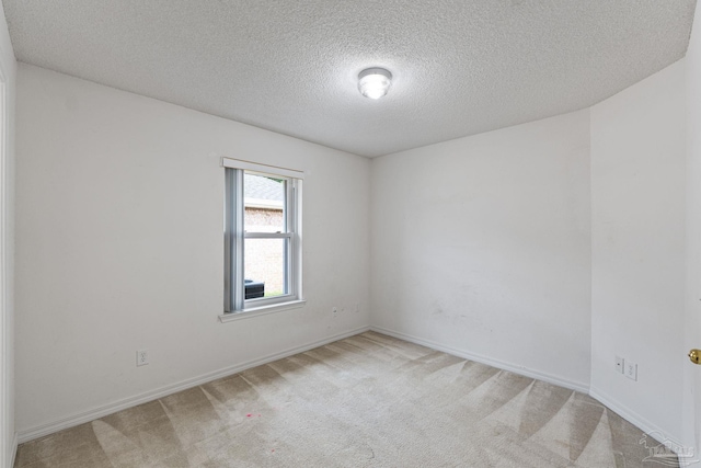 carpeted spare room with baseboards and a textured ceiling