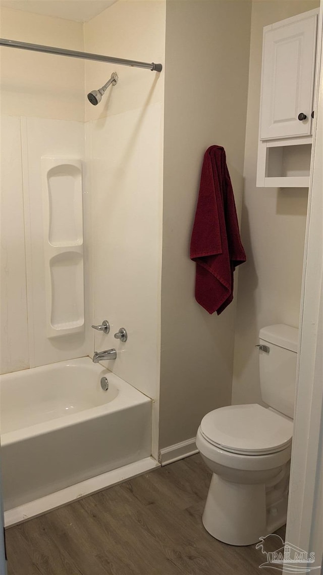 bathroom featuring bathing tub / shower combination, toilet, and hardwood / wood-style floors