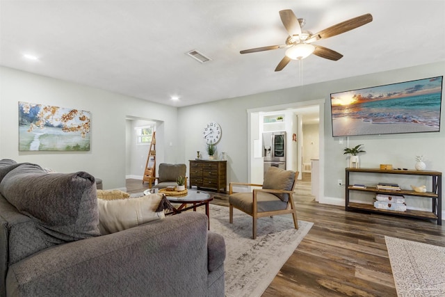 living room with dark wood-type flooring and ceiling fan