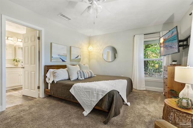 bedroom featuring light carpet, connected bathroom, and ceiling fan