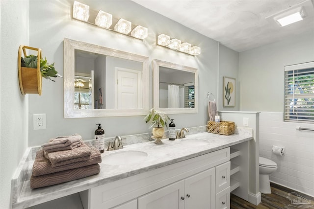 bathroom featuring hardwood / wood-style flooring, vanity, tile walls, and toilet