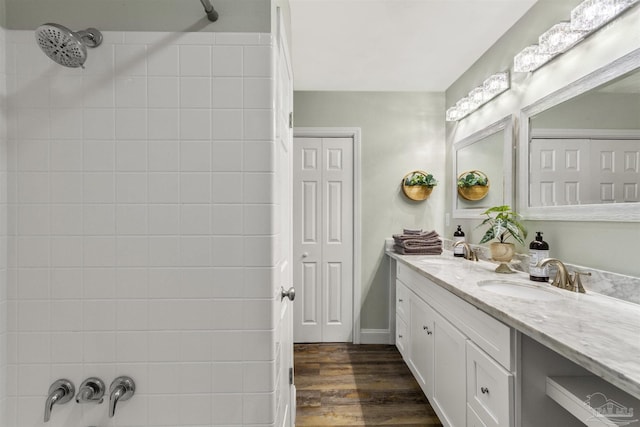 bathroom featuring hardwood / wood-style flooring, vanity, and tiled shower / bath combo