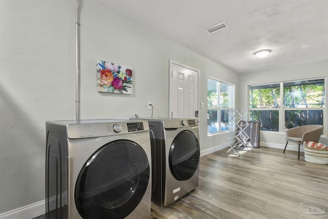 laundry area with hardwood / wood-style flooring and washer and dryer