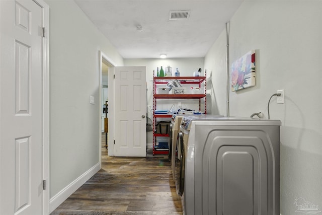 laundry area featuring dark hardwood / wood-style flooring and washing machine and clothes dryer