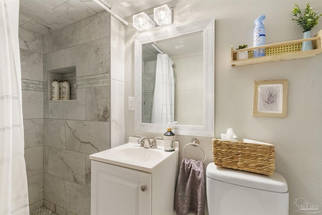 bathroom featuring vanity, walk in shower, and toilet