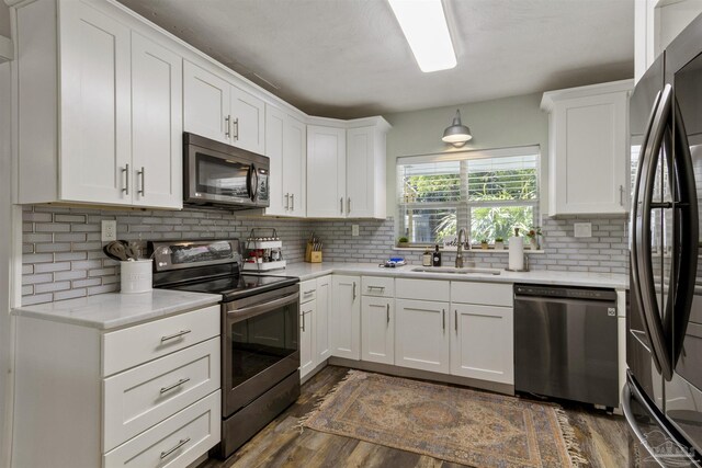 kitchen featuring tasteful backsplash, white cabinetry, appliances with stainless steel finishes, and sink