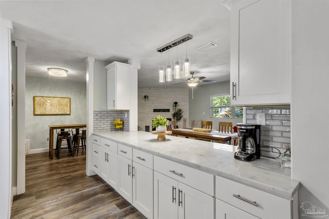 kitchen with ceiling fan, white cabinetry, dark hardwood / wood-style floors, tasteful backsplash, and light stone countertops