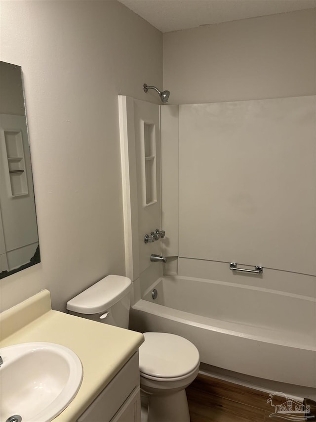 full bath featuring vanity, toilet, wood finished floors, and tub / shower combination