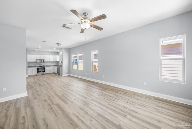 unfurnished living room featuring ceiling fan and light hardwood / wood-style floors