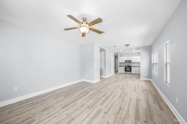 unfurnished living room featuring ceiling fan and light hardwood / wood-style floors