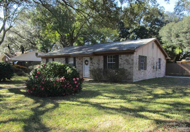 ranch-style home with a front yard and brick siding