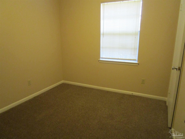 carpeted empty room featuring baseboards