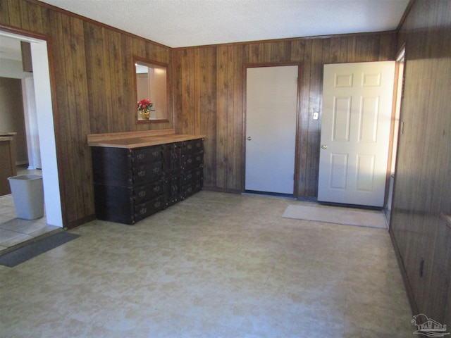 unfurnished bedroom with wood walls and light floors