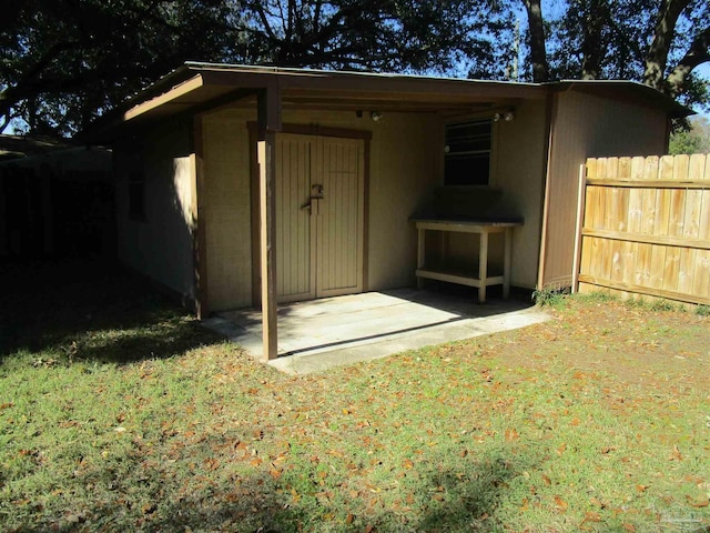 view of outbuilding featuring fence