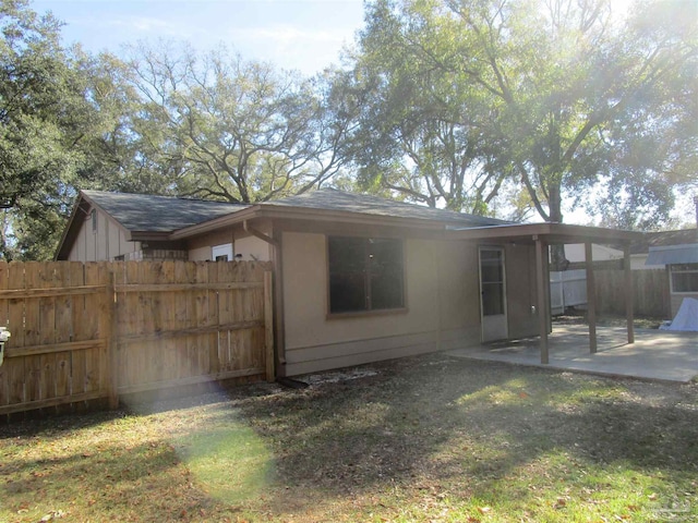 back of property featuring a patio area, a lawn, and fence