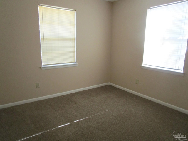 spare room featuring carpet flooring and baseboards