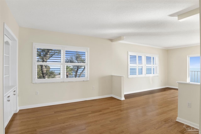 unfurnished room featuring hardwood / wood-style floors and a textured ceiling