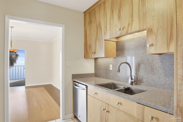 kitchen featuring light stone counters, sink, stainless steel dishwasher, and light brown cabinetry