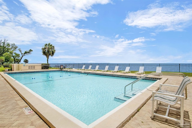 view of pool with a patio and a water view