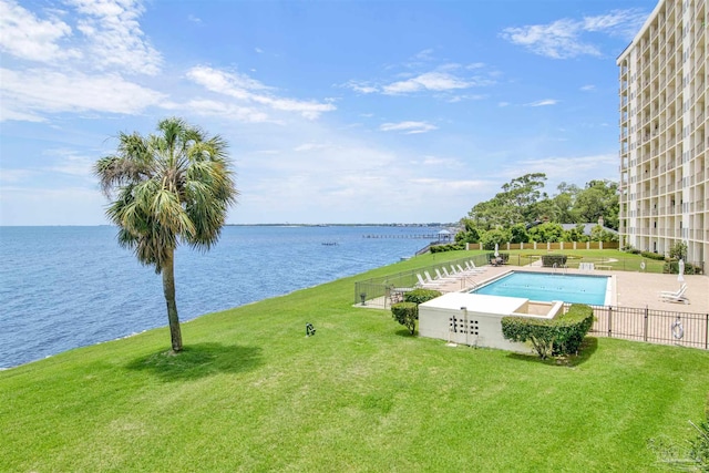 view of swimming pool featuring a lawn and a water view