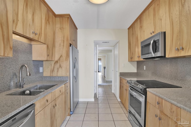 kitchen featuring sink, tasteful backsplash, light tile patterned floors, stainless steel appliances, and light stone countertops