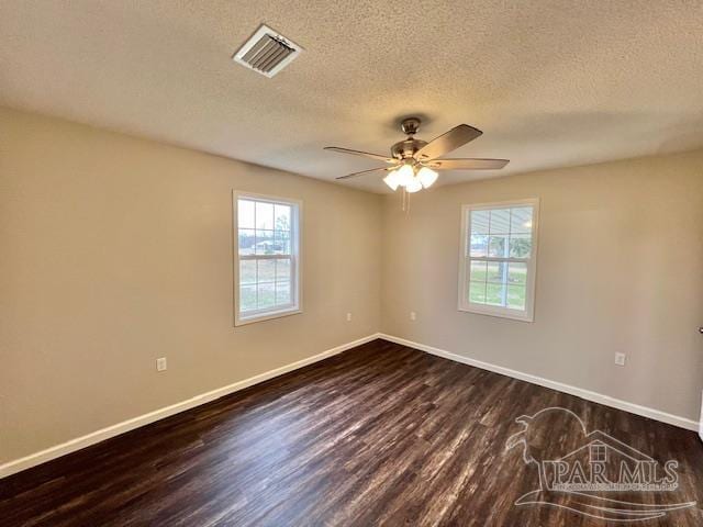 empty room featuring a ceiling fan, dark wood-style flooring, visible vents, and baseboards