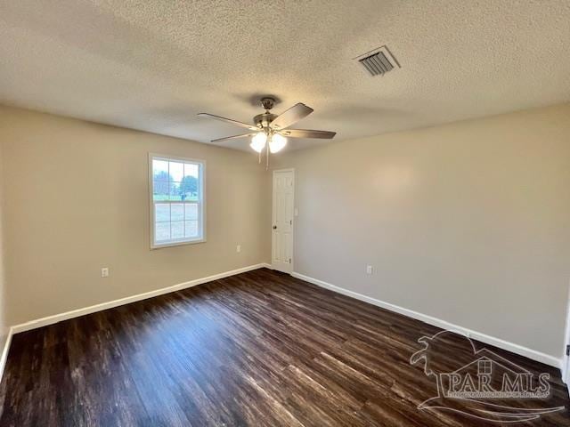 unfurnished room featuring dark wood-style floors, visible vents, ceiling fan, a textured ceiling, and baseboards