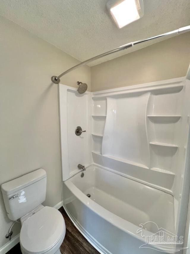 full bathroom with a textured ceiling, bathtub / shower combination, toilet, wood finished floors, and baseboards