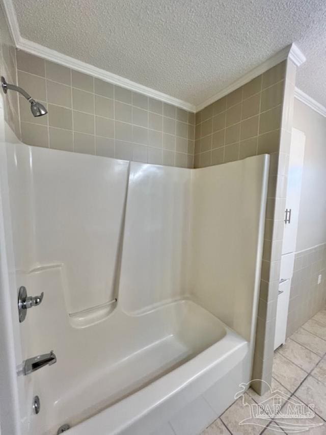 bathroom featuring a textured ceiling, bathing tub / shower combination, and tile patterned floors