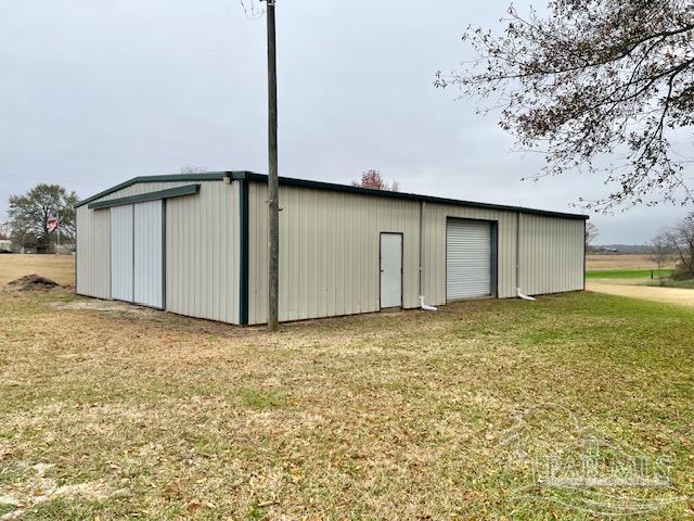 view of outdoor structure with driveway and an outbuilding