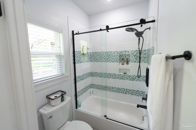 bathroom with bath / shower combo with glass door and toilet