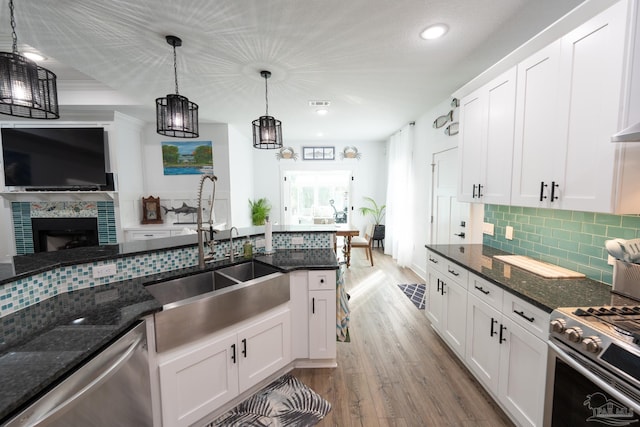 kitchen featuring decorative light fixtures, white cabinetry, stainless steel appliances, and sink