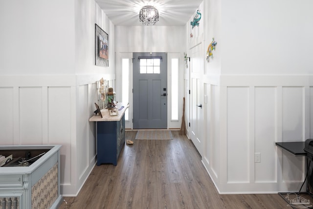 foyer entrance featuring wood-type flooring and a notable chandelier