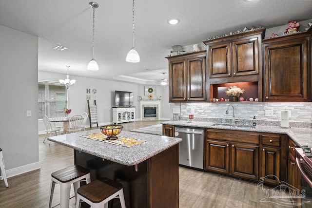 kitchen featuring stainless steel appliances, a sink, decorative backsplash, light wood-style floors, and recessed lighting