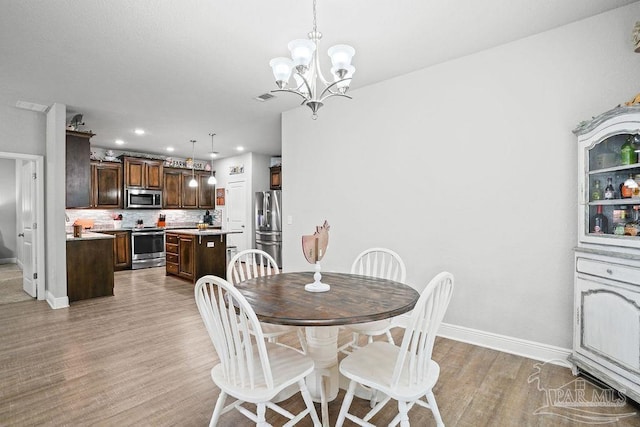 dining room featuring baseboards, light wood-style floors, a chandelier, and recessed lighting