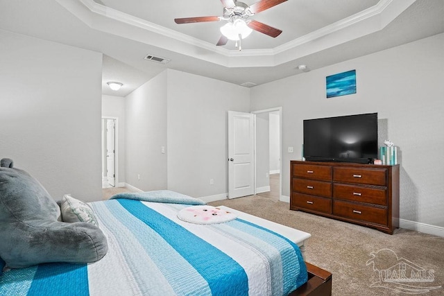 bedroom with a tray ceiling, light carpet, ornamental molding, baseboards, and a ceiling fan
