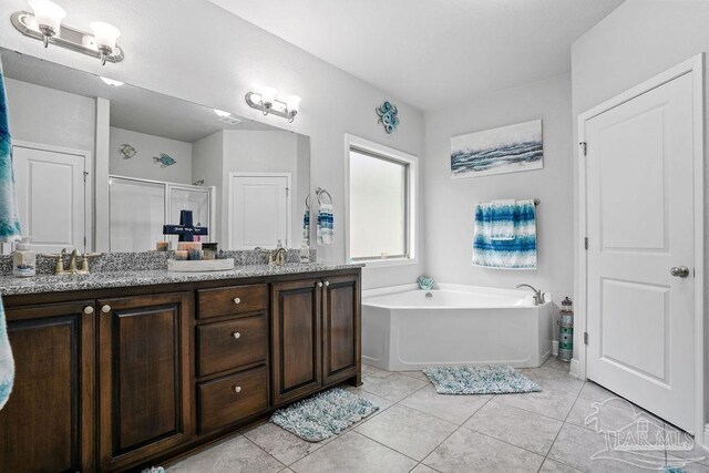 bathroom with tile patterned floors, a shower stall, double vanity, and a garden tub