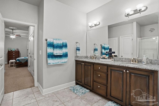 full bath featuring a shower stall, double vanity, ceiling fan, tile patterned flooring, and baseboards