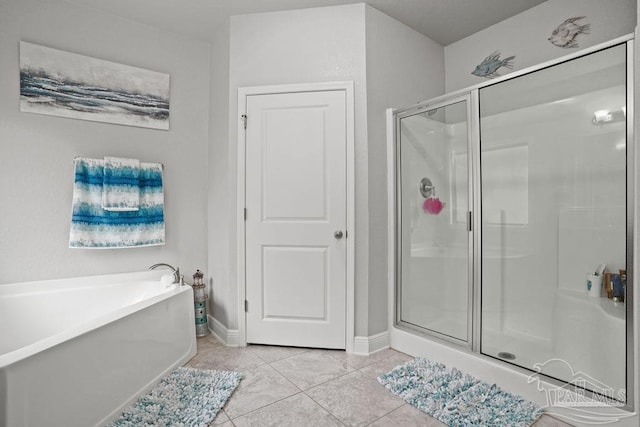 full bathroom featuring tile patterned floors, a bathtub, a shower stall, and baseboards