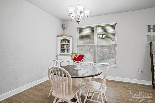 dining room featuring baseboards, a chandelier, and wood finished floors