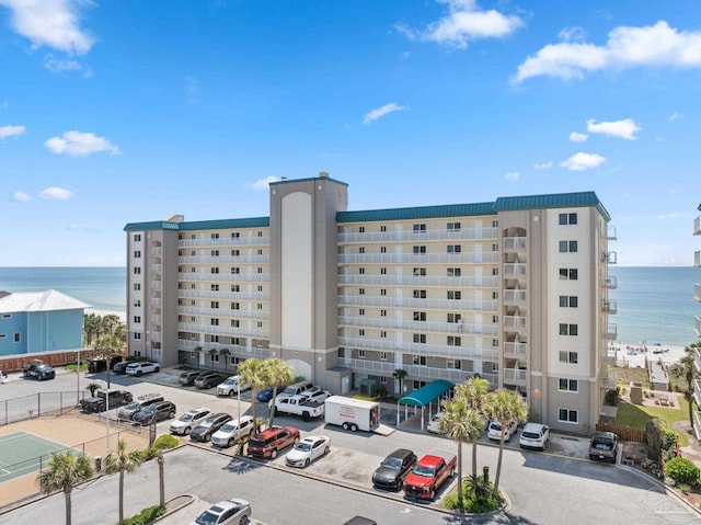 view of building exterior with a water view and uncovered parking