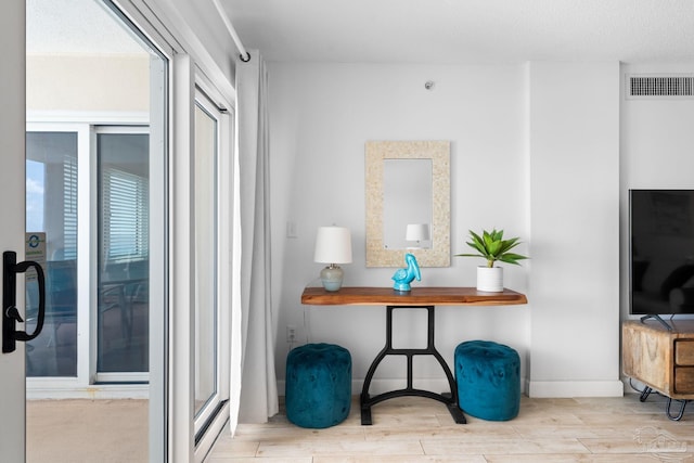 interior space featuring baseboards, visible vents, and wood finished floors
