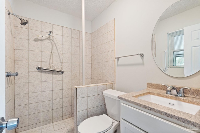 full bath with a tile shower, toilet, and a textured ceiling