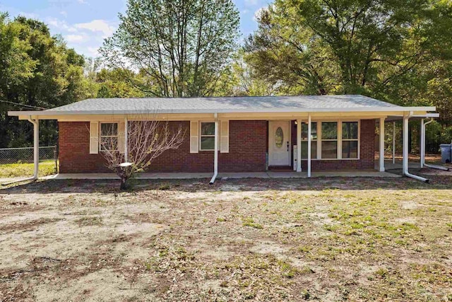 ranch-style house with brick siding, a porch, and fence