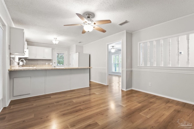 kitchen with visible vents, wood finished floors, ceiling fan, and freestanding refrigerator