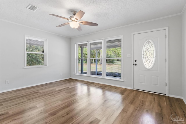 entryway with wood finished floors, plenty of natural light, ceiling fan, and visible vents