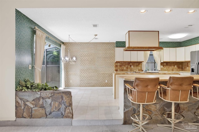kitchen featuring white cabinets, visible vents, recessed lighting, and light tile patterned floors